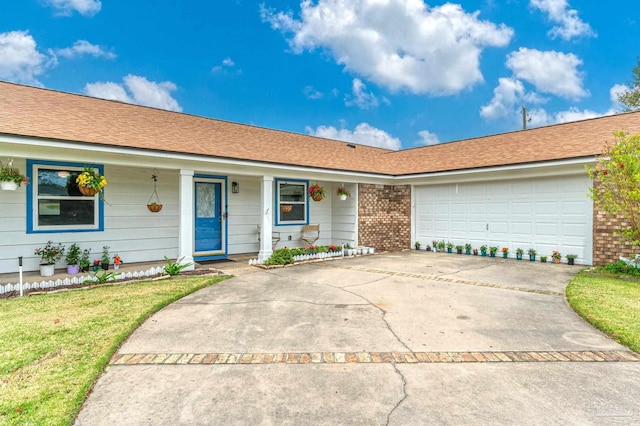 single story home with covered porch, concrete driveway, brick siding, an attached garage, and a front yard