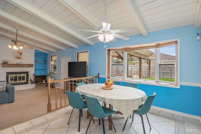 dining area featuring lofted ceiling with beams, a ceiling fan, wooden ceiling, and a brick fireplace