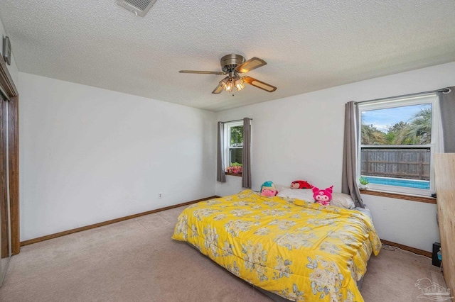 carpeted bedroom with a textured ceiling, visible vents, and multiple windows