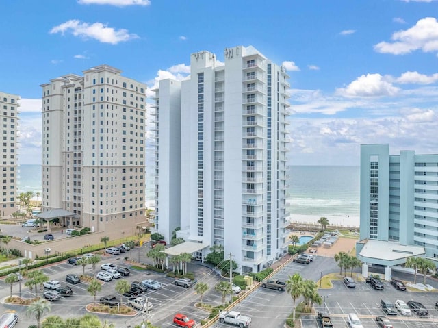 view of property featuring a view of city, a water view, and uncovered parking