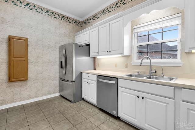 kitchen featuring light tile patterned floors, light countertops, appliances with stainless steel finishes, white cabinets, and a sink