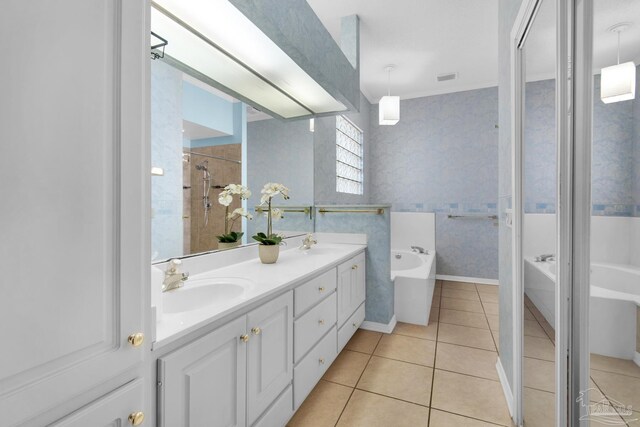 full bath with double vanity, wallpapered walls, a sink, a bath, and tile patterned floors