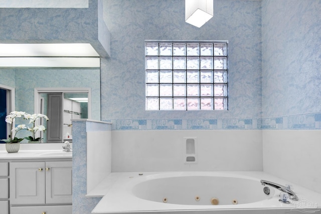 full bathroom with a whirlpool tub, wallpapered walls, and vanity