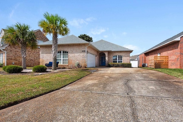 view of front of home with brick siding, a shingled roof, an attached garage, driveway, and a front lawn