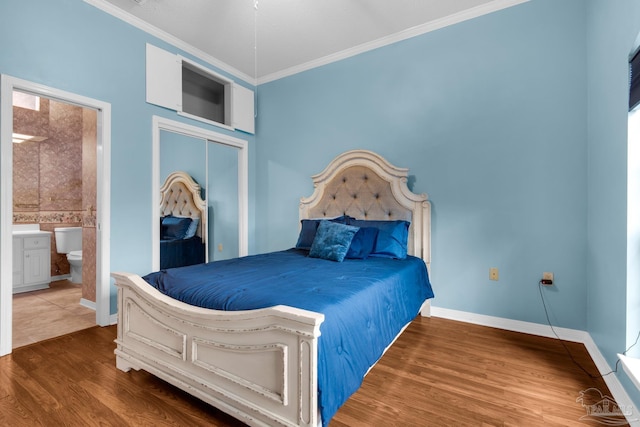 bedroom with ornamental molding, a closet, wood finished floors, and baseboards