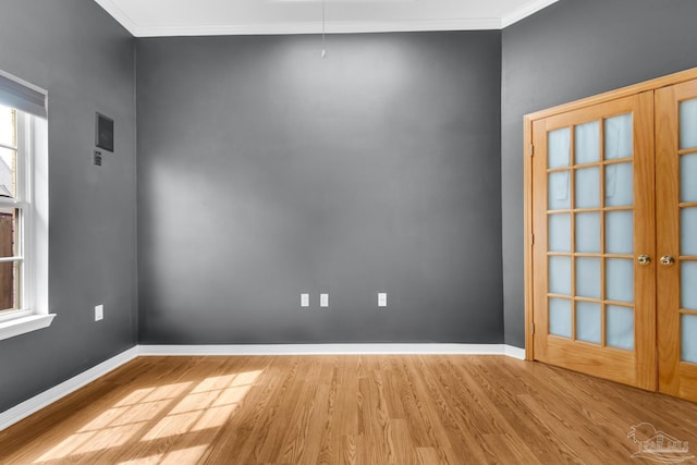 unfurnished room with french doors, crown molding, baseboards, and wood finished floors