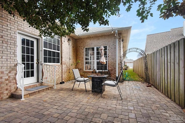 view of patio / terrace with entry steps, a fire pit, and fence