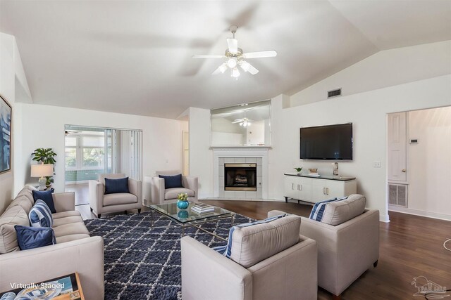 living area featuring lofted ceiling, visible vents, dark wood finished floors, and a tile fireplace