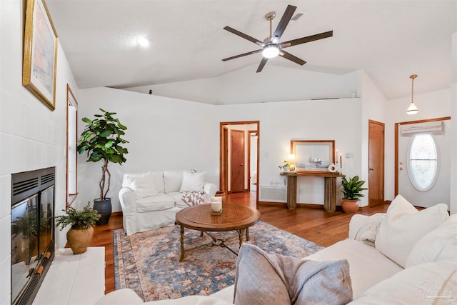 living room featuring light hardwood / wood-style floors, vaulted ceiling, and ceiling fan