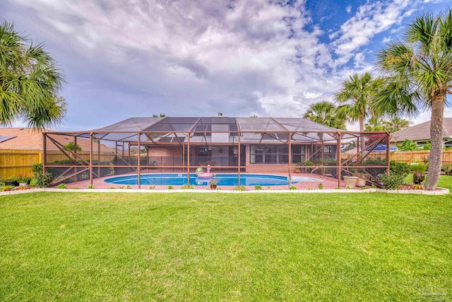 view of swimming pool featuring a yard and glass enclosure