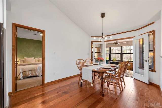 dining space with a notable chandelier, vaulted ceiling, and hardwood / wood-style flooring