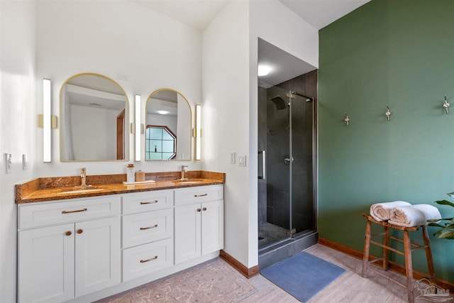 bathroom featuring wood-type flooring, vanity, and a shower with shower door