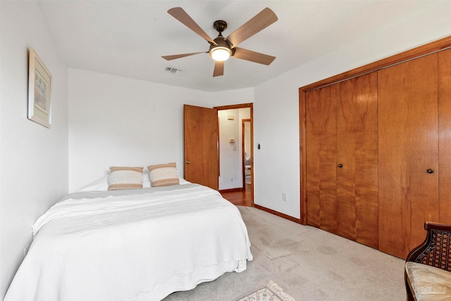 bedroom featuring ceiling fan, light colored carpet, and a closet