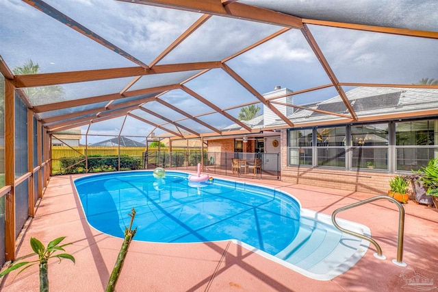 view of pool featuring glass enclosure and a patio