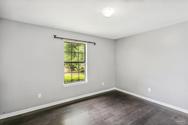 unfurnished room with dark wood-type flooring