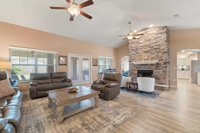 3246 Main St, Navarre, FL 32566 - living area with arched walkways, a stone fireplace, visible vents, a ceiling fan, and light wood finished floors