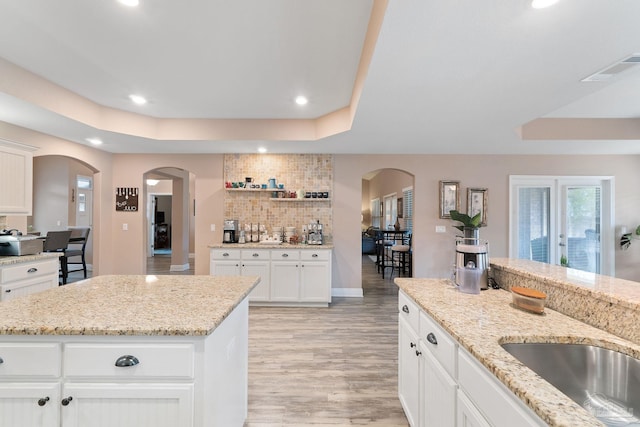 3246 Main St, Navarre, FL 32566 - kitchen with arched walkways, a tray ceiling, and backsplash