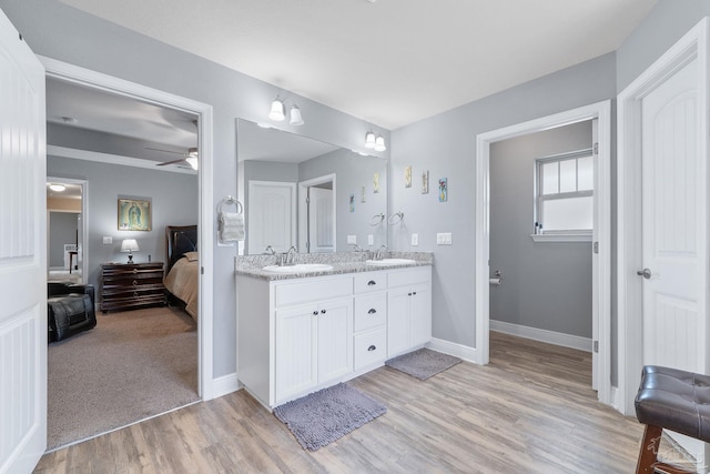 3246 Main St, Navarre, FL 32566 - full bathroom with double vanity, ensuite bath, a sink, and wood finished floors