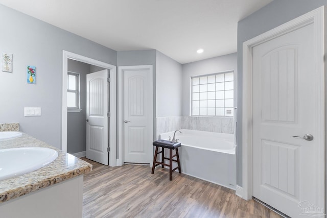 3246 Main St, Navarre, FL 32566 - bathroom with a healthy amount of sunlight, a sink, a bath, and wood finished floors