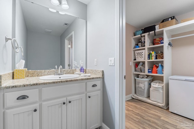 3246 Main St, Navarre, FL 32566 - bathroom with visible vents, wood finished floors, vanity, and baseboards