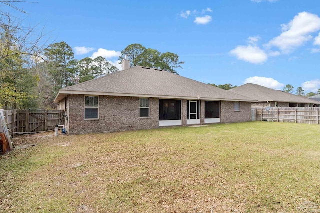 3246 Main St, Navarre, FL 32566 - back of house with a yard, brick siding, a chimney, and a fenced backyard