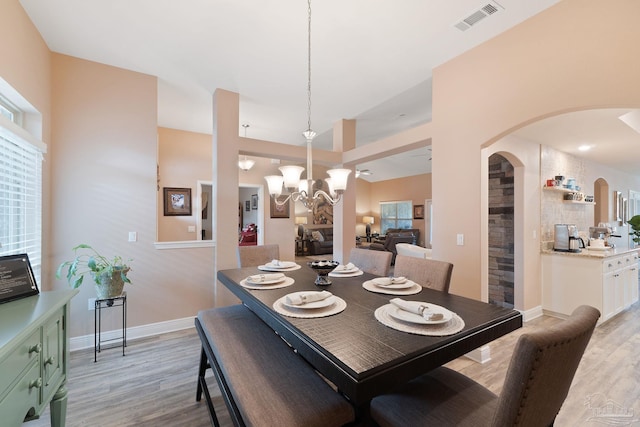 3246 Main St, Navarre, FL 32566 - dining room featuring light wood-type flooring, visible vents, arched walkways, and a notable chandelier