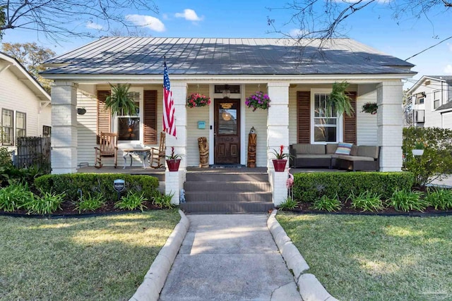 bungalow with covered porch and a front lawn