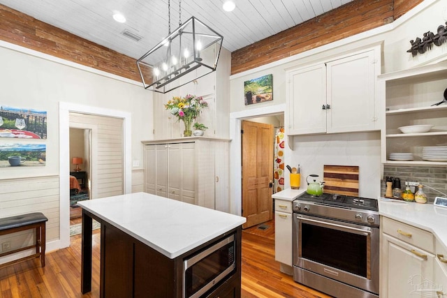 kitchen featuring visible vents, light countertops, decorative backsplash, appliances with stainless steel finishes, and wood finished floors