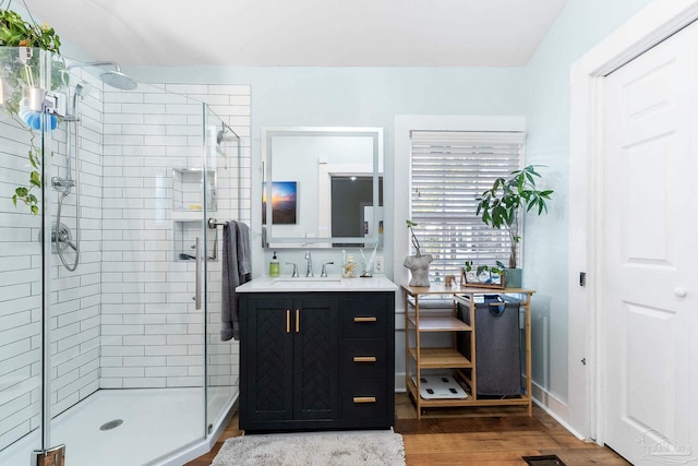 full bathroom featuring vanity, wood finished floors, and a shower stall