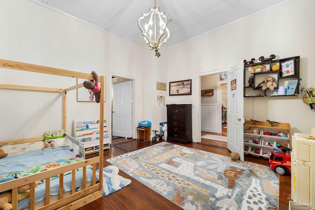 bedroom featuring a notable chandelier, crown molding, and wood finished floors