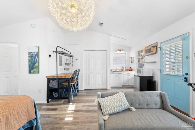 bedroom with light wood finished floors, visible vents, baseboards, and vaulted ceiling