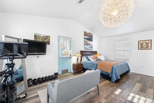 bedroom featuring lofted ceiling, a notable chandelier, wood finished floors, and visible vents