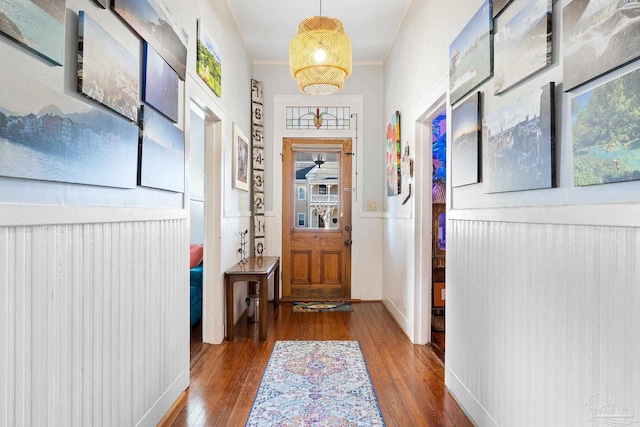 doorway to outside with crown molding and wood finished floors