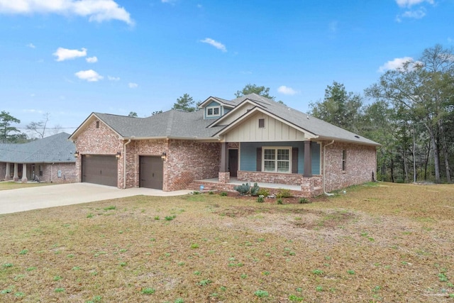 view of front of property with a garage, a front yard, brick siding, and a porch