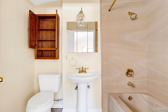 bathroom with toilet and tiled shower / bath