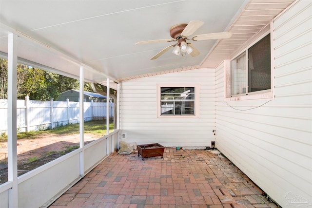 unfurnished sunroom with a wealth of natural light, lofted ceiling, and ceiling fan