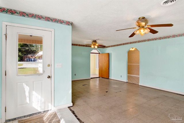 foyer entrance with a textured ceiling and ceiling fan