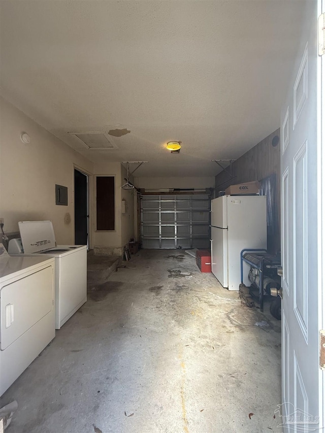 garage with washer and dryer and white fridge