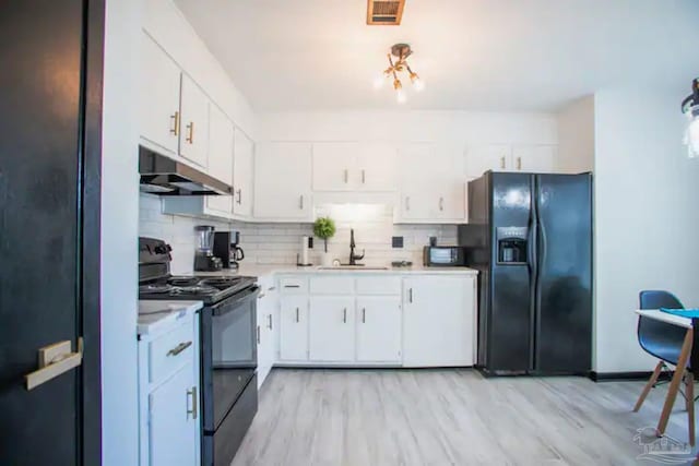 kitchen featuring black appliances, sink, white cabinetry, and light hardwood / wood-style flooring