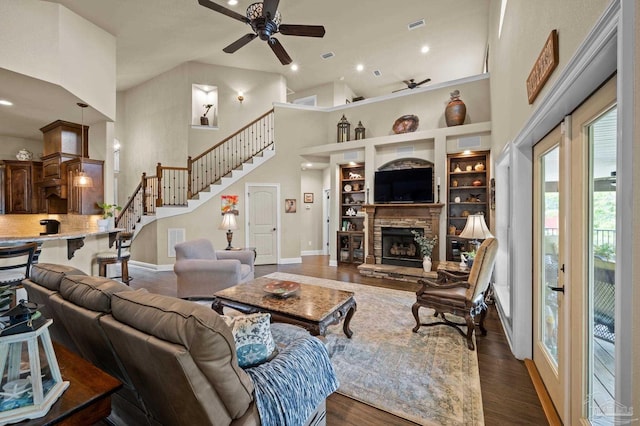 living area featuring dark wood-style floors, high vaulted ceiling, ceiling fan, and a fireplace