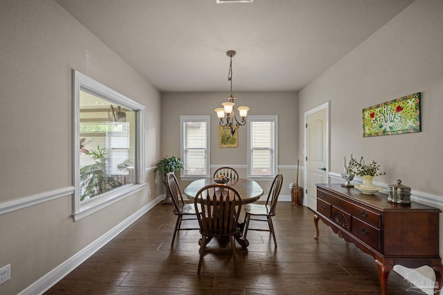 dining room with dark wood-style floors, a notable chandelier, and baseboards