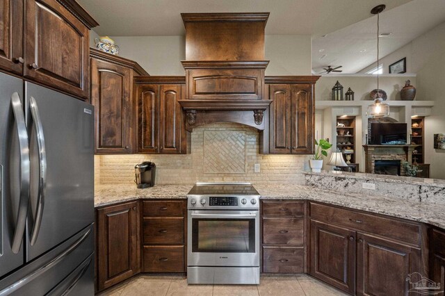 kitchen featuring dark brown cabinetry, tasteful backsplash, appliances with stainless steel finishes, and a fireplace