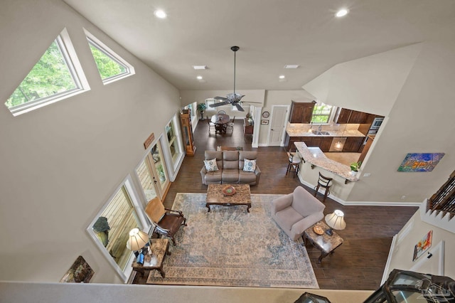 living area with vaulted ceiling, plenty of natural light, dark wood-style floors, and recessed lighting