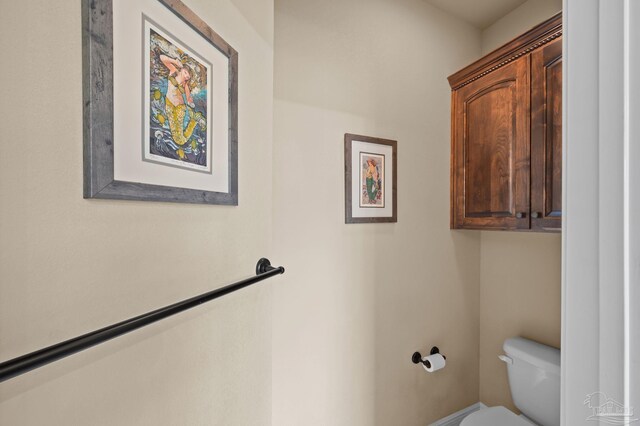 bathroom with toilet and baseboards