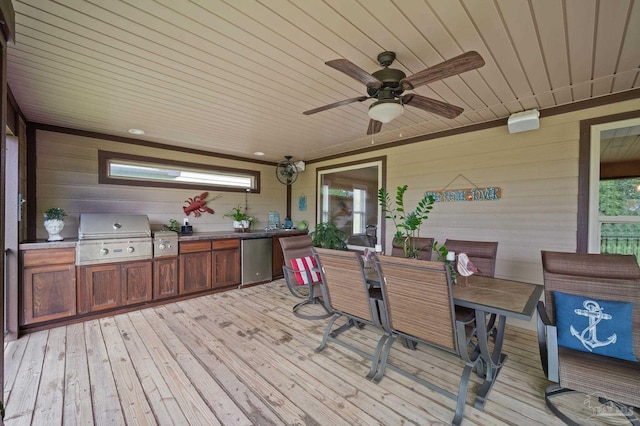 wooden deck featuring ceiling fan, outdoor dining space, grilling area, and exterior kitchen