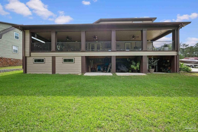 back of house with a lawn and a ceiling fan