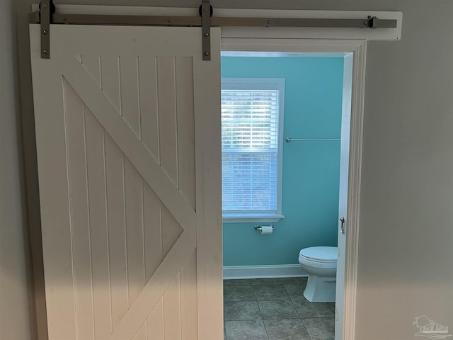 bathroom with toilet and tile patterned flooring