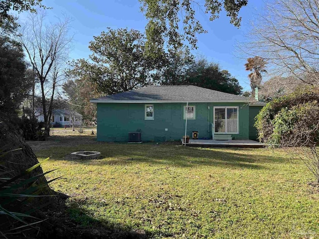 back of property featuring central AC unit, a fire pit, a lawn, and a patio