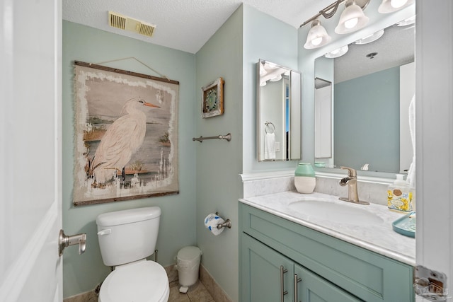 bathroom with vanity, tile patterned floors, a textured ceiling, and toilet