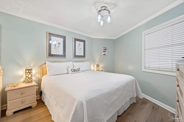 bedroom with crown molding, light hardwood / wood-style flooring, and a textured ceiling